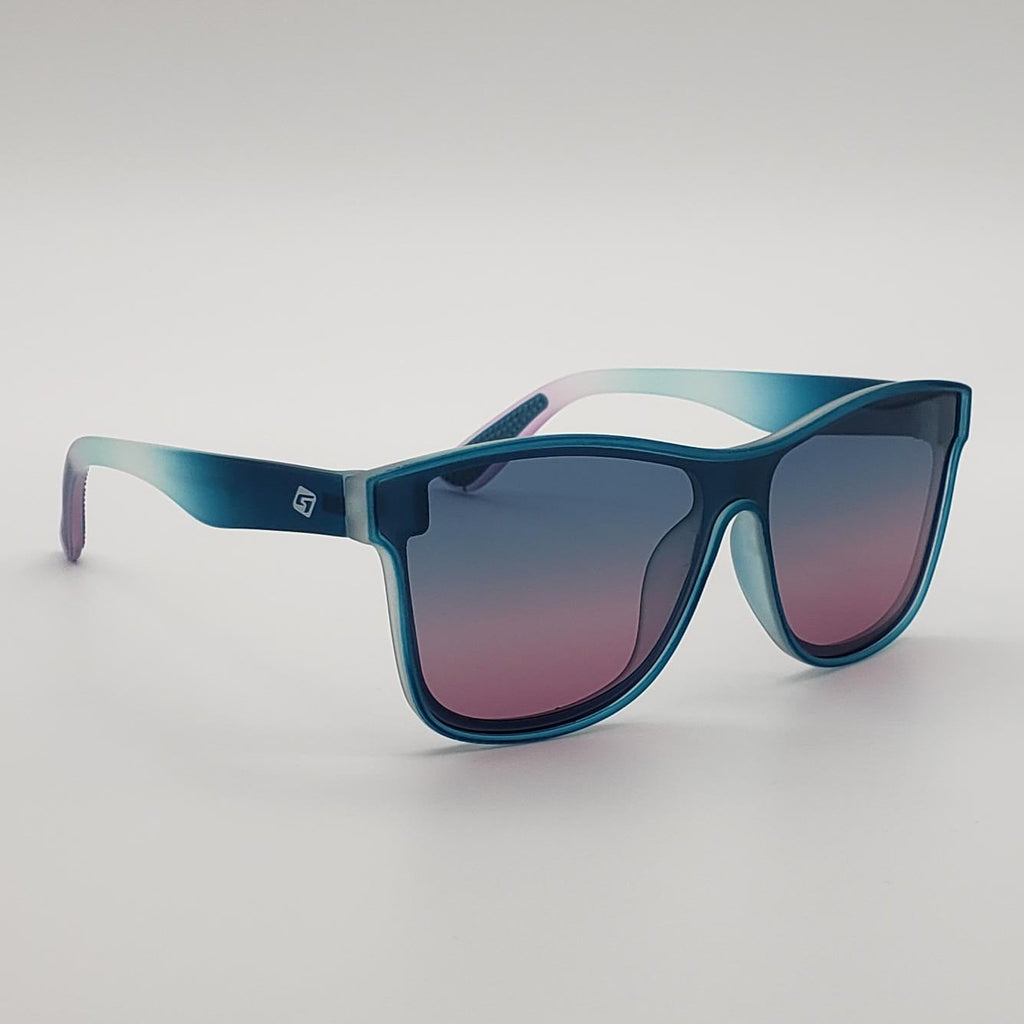 A pair of oversized square sunglasses with a translucent blue-to-purple gradient frame and matching gradient lenses, shown on a neutral light gray background.