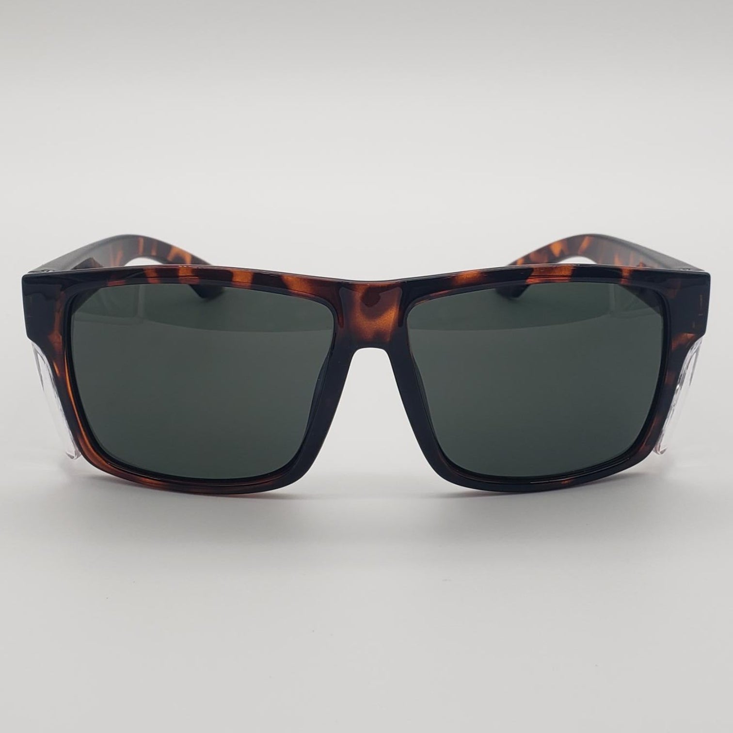 A pair of square sunglasses with a dark brown and black tortoiseshell frame and dark gray lenses, shown against a neutral light gray background.